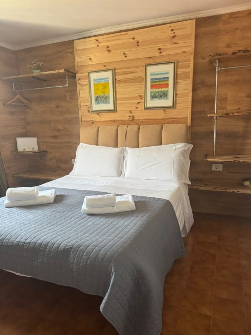 Camera da letto rustica in legno con biancheria e asciugamani bianchi presso THE V Collection a Sormano, Italia