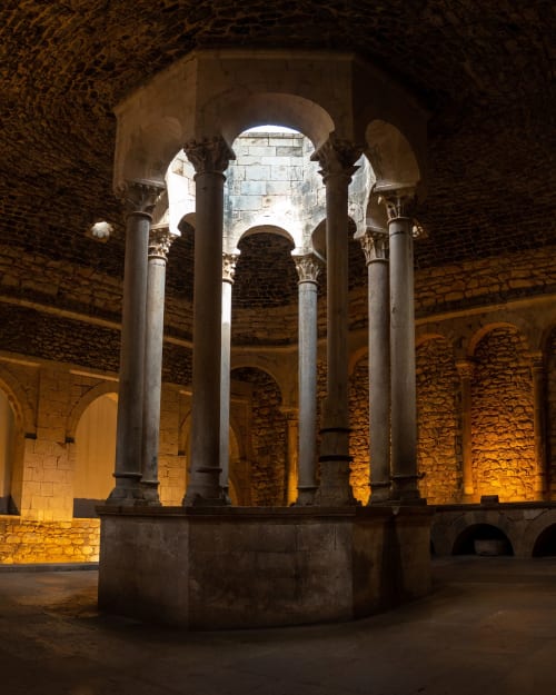 Ancient stone columns and arches in historic courtyard at Alemanys 5 boutique hotel, Barcelona Spain
