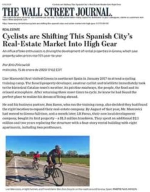 Cyclists riding on rural road near Girona, Spain with countryside landscape