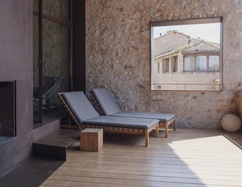 Modern terrace at Alemanys 5 with lounge chairs, stone walls, and countryside views in Spain