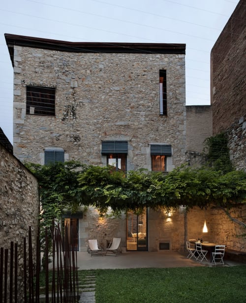 Alemanys 5 courtyard at dusk with stone architecture, modern amenities, and intimate seating in Spain
