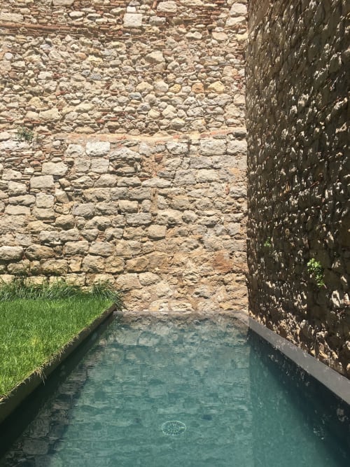 Narrow stone courtyard with water channel at Alemanys 5 guesthouse, Spain
