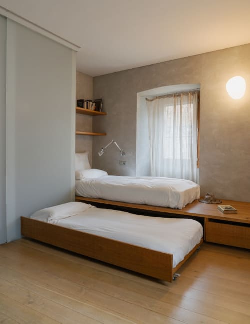 Modern twin bedroom at Alemanys 5 B&B with wooden beds, taupe walls, and natural light from large windows