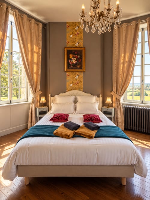 Élégante chambre double au Château de Montbrault avec lit à baldaquin, vue sur jardin, lustre en cristal et décor raffiné