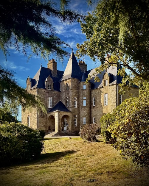 Château de Montbrault, un château de pierre aux tourelles et toits mansardés, entouré de jardins à la française à Fleurigné