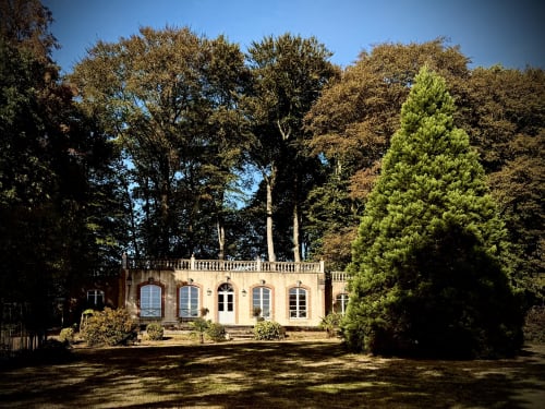 Élégant petit château de charme aux tons crème niché dans la forêt automnale du Château de Montbrault, Fleurigné