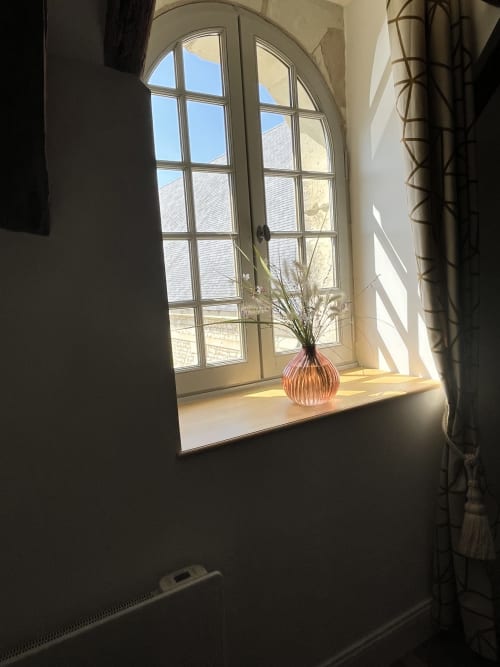 Fenêtre cintrée dans un gîte rural français avec vase rouge et fleurs séchées, vue campagnarde, Gîte 1694