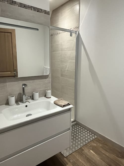 Salle de bain moderne avec meuble vasque et douche à l'italienne au gîte 1694 à Scorbe-Clairvaux, France