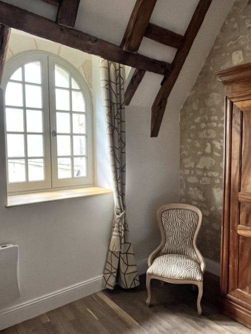 Fenêtre en arc avec rideaux à motifs et chaise zébrée dans le gîte 1694, Scorbe Clairvaux