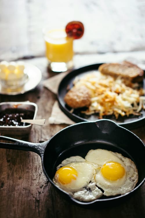 Desayuno rústico en el hotel Alto Gredos con huevos fritos, papas al horno, tostadas y jugo fresco en Hoyos del Espino