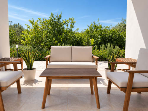 Terrazza di Villa Eraklea a Noto con mobili in legno, piante in vaso e vedute sul giardino mediterraneo