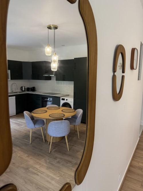Cuisine-salle à manger moderne à Le Clos de l'Arguenon avec table ronde, chaises bleues et luminaires suspendus