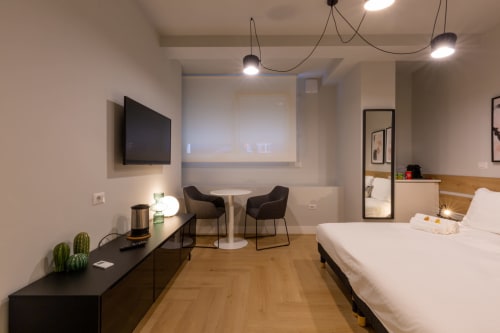 Camera moderna di Casa Lounge Istria a Cagliari con letto, scrivania, TV, zona living e pavimenti in legno