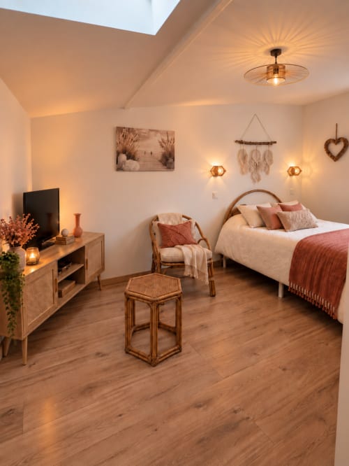 Chambre Bohemia à L'Échappée Baie B&B à Roz-sur-Couesnon avec éclairage chaleureux, mobilier en bois et vue sur le jardin