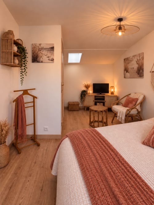 Chambre Bohemia à L'Echappée Baie B&B à Roz-sur-Couesnon avec lit, TV, fauteuil en rotin et ambiance chaleureuse