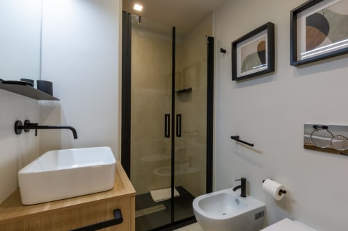 Bagno moderno di Casa Lounge Istria Cagliari con lavabo a bacinella, doccia pioggia e rubinetteria nera