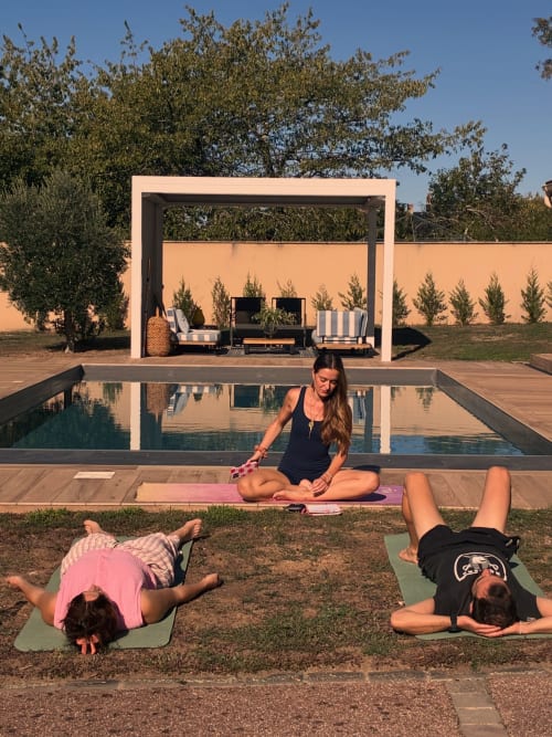Cours de yoga à la piscine du Clos d'Émilie avec instructeur et participants sur tapis