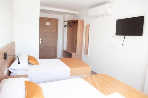 Habitación doble moderna en Hostal Restaurante Angel en Huelma con dos camas, TV de pantalla plana, muebles de madera y aire acondicionado