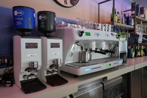 Máquinas de espresso profesionales y molinillo de café en la barra del Hostal Restaurante Angel en Huelma, Jaén