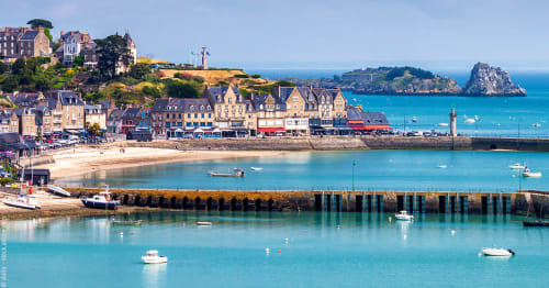 Charmante ville côtière avec bâtiments colorés, plage de sable, eaux turquoise et bateaux près de L'Échappée Baie,
