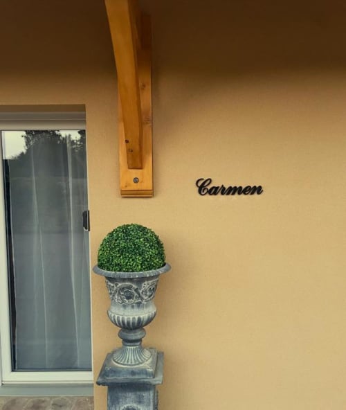 Entrée de la Maison Carmen au gîte Le Clos d'Émilie avec urne décorative et topiaire