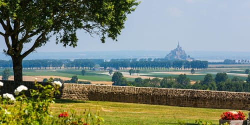 Mont-Saint-Michel vu du jardin L'Echappée Baie à Roz-sur-Couesnon, Normandie, avec champs et mur de pierre