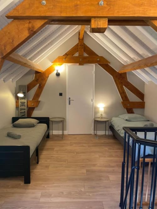 Chambre mansardée au Clos d'Émilie avec poutres apparentes, deux lits et fenêtres de toit en France