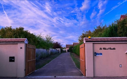 Entrée rose du gîte Le Clos d'Émilie en France au crépuscule avec ciel bleu