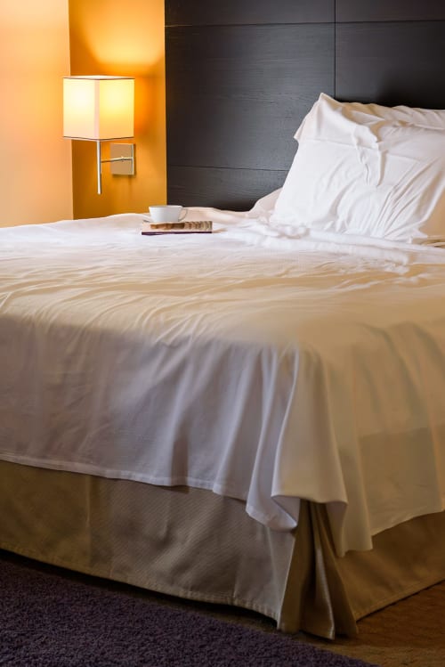 Camera Deluxe Hotel FortyFive a Chivasso con biancheria bianca, lampada da scrivania e testata moderna scura