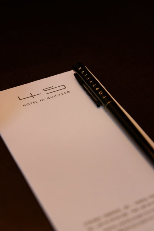 Cartoleria Hotel FortyFive di Chivasso con penna su blocco note bianco su sfondo scuro