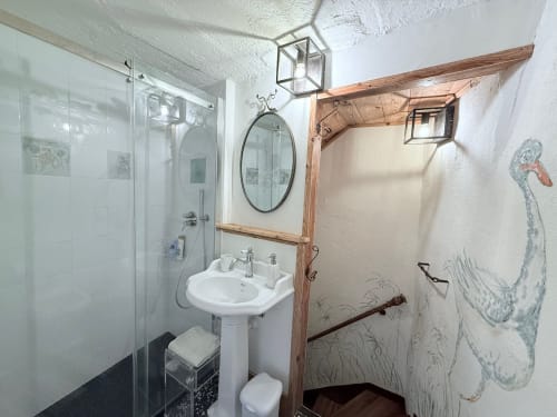 Vista del bagno della Suite Drago presso la struttura Roseto del Drago a Ponte in Valtellina (Sondrio): dotato di un moderno ed ampio box doccia in vetro, lavandino su colonna e dettagli in legno rustico.