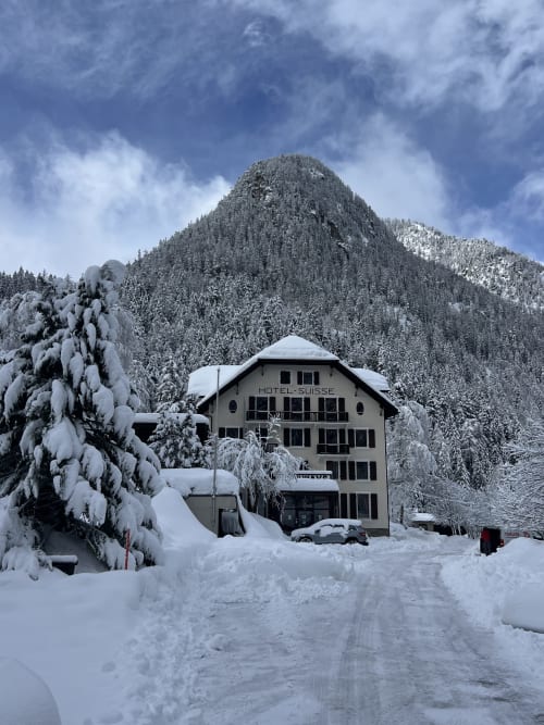 Hotel Suisse à Champex-Lac entouré de montagnes enneigées et de forêts en hiver