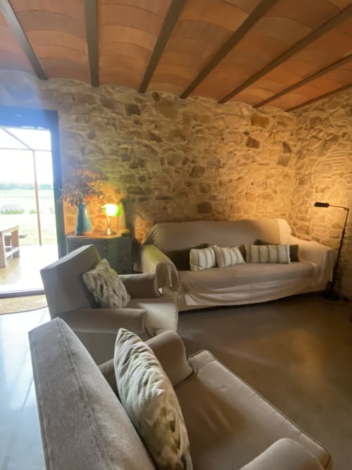 Sala de estar rústica con sofás beige y vigas de madera en la villa Can Serrà 1786 en Llagostera