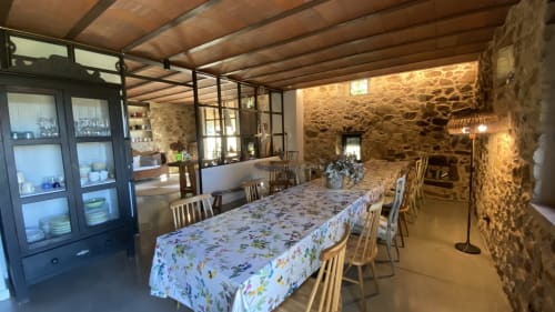 Comedor espacioso de la villa Can Serrà 1786 en Llagostera con mesa larga, vigas de madera y muros de piedra