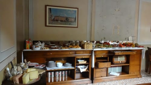 Buffet allestito nella suite junior dell'Albergo Giulia Gonzaga a Sabbioneta, con pasticcini e rinfreschi su mobili in legno