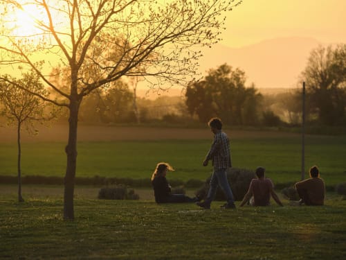 Grupo de amigos reunidos al atardecer en una villa rural de la campiña catalana cerca de Llagostera, España