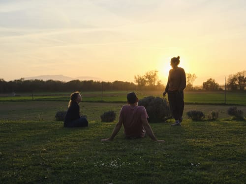 Tres personas relajándose en el atardecer en los campos de la villa Can Serrà 1786 en Llagostera, España