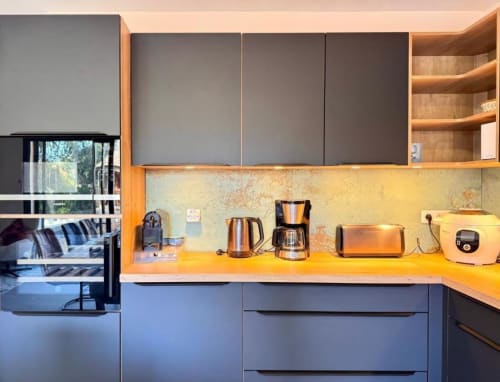 Cuisine de villa moderne avec dosseret jaune, armoires grises et appareils en acier inoxydable aux Villas d'A Storia