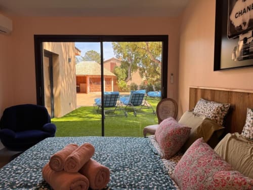 Chambre Villa Dolce Vita avec vue sur jardin, chaises bleues sur la pelouse, hébergement resort Porto-Vecchio