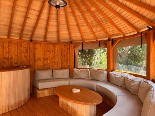 Salon circulaire en bois avec sièges rembourrés et table ovale à la Villa Dolce Vita, Porto-Vecchio