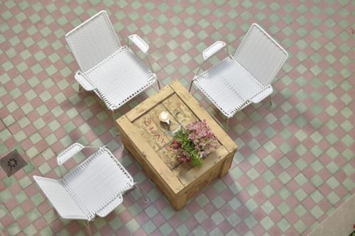 Sillas de mimbre blanco alrededor de mesa de madera con flores rosas en la terraza de Casa Cafeólogo en San Cristóbal de las Casas