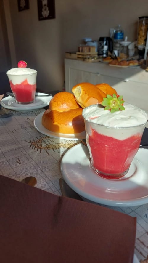 Dolci e bevande presso U Baruni b&b Messina: sfogliatelle dorate, bevande stratificate rosse e guarnizioni di frutta fresca su bianco