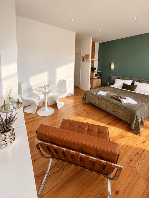 Suite de Design à la Maison Farol avec sièges en cuir cognac, mur d'accent vert et parquet à Salles
