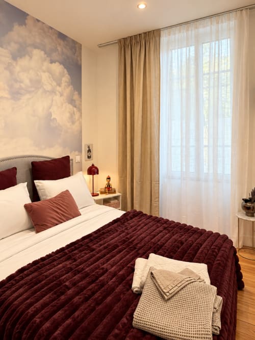 Chambre vintage à la Maison Farol B&B avec literie bordeaux, fresque nuages, vue jardin et rideaux neutres