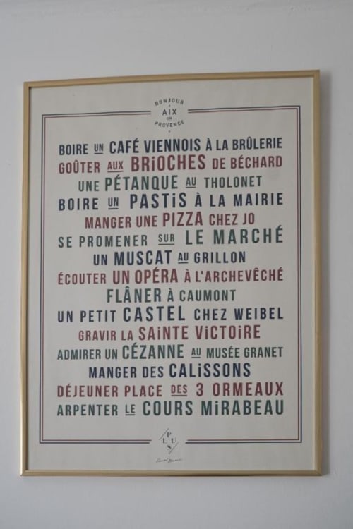 Affiche vintage française encadrée listant les incontournables d'Aix-en-Provence, en décoration dans la chambre Nature des gîtes de Val