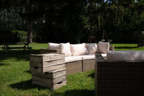 Espace de détente dans le jardin des gîtes de Val avec mobilier en osier et matières naturelles