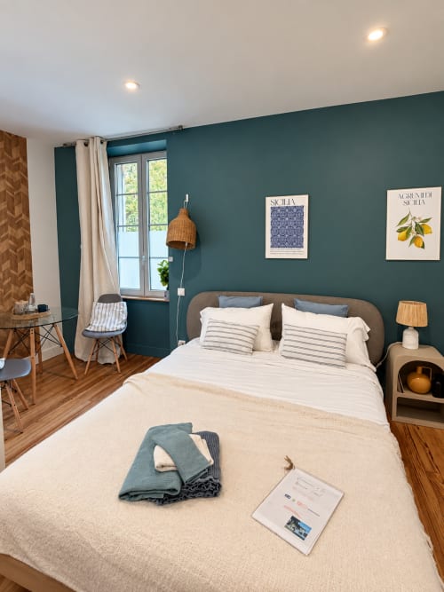 Chambre de style méditerranéen à la Maison Farol avec un mur d'accent bleu canard, lit double, mobilier en bois et vue sur le jardin