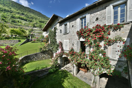 Casetta in pietra a Roseto del Drago, Ponte in Valtellina, con rose rampicanti rosse, giardini e vista sulle montagne