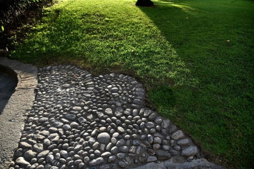 Sentiero del giardino con pietre decorative del fiume e prato verde rigoglioso a Roseto del Drago, Ponte in Valtellina