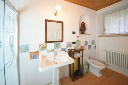 Bagno dell'appartamento Piano Nobile a Roseto del Drago, Ponte in Valtellina, con lavabo, water, piastrelle decorative e